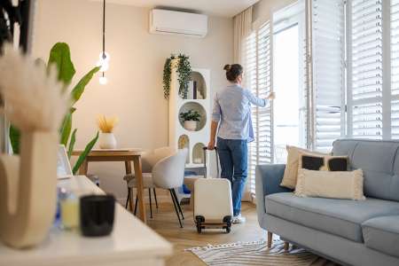 Foto: Frau öffnet Fenster in Wohnung