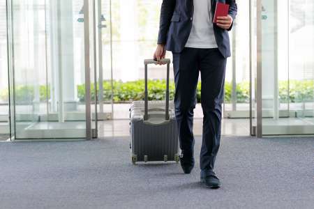 Foto: Mann mit Koffer am Flughafen